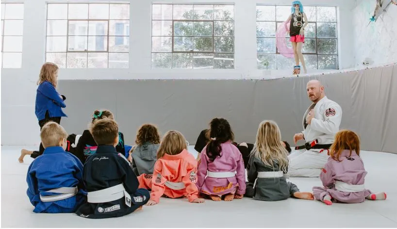 Child learning Brazilian Jiu-Jitsu technique on the mat.