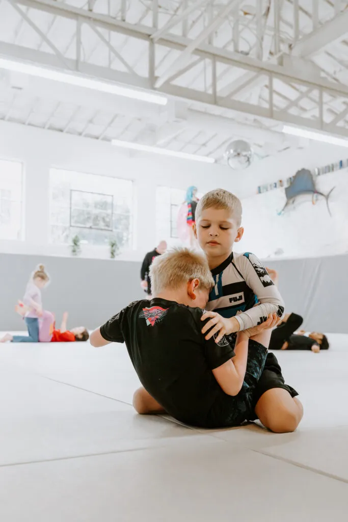 Two kids practicing BJJ during a kids martial arts class in Decatur, GA at SuperFly BJJ.