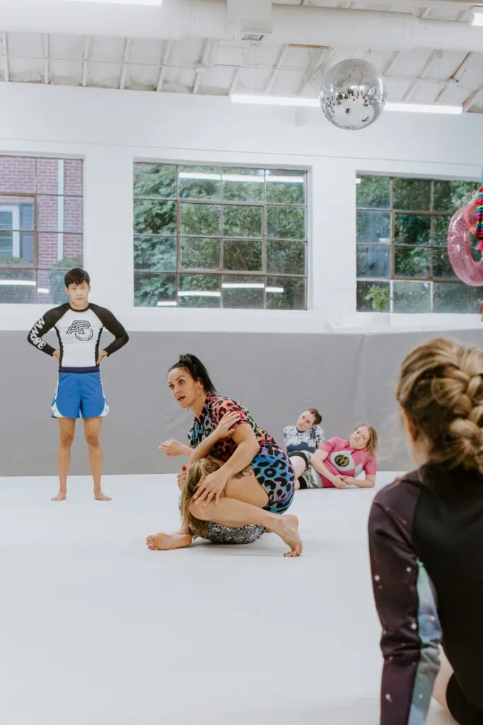A female instructor demonstrates a self-defense technique during a women-only BJJ class at SuperFly BJJ in Decatur, GA.