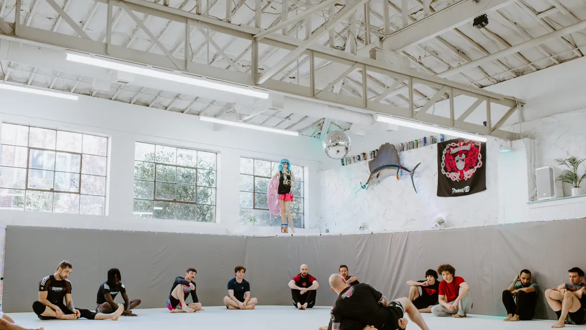 Students observing a Brazilian Jiu-Jitsu technique demonstration in a fundamentals class at SuperFly BJJ