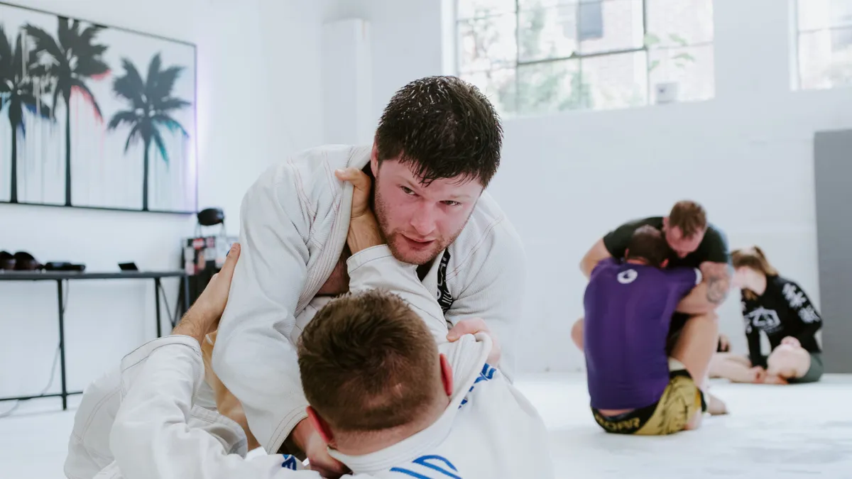 Gi students practicing grappling techniques during a Brazilian Jiu-Jitsu class at SuperFly BJJ