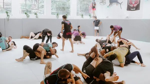 Adults rolling during live No-Gi sparring at SuperFly BJJ