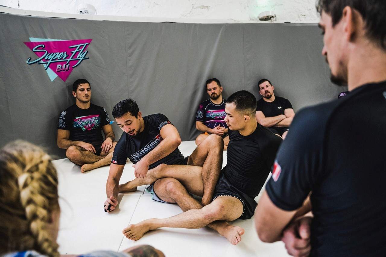 Adults practicing Brazilian Jiu-Jitsu during fall season training.