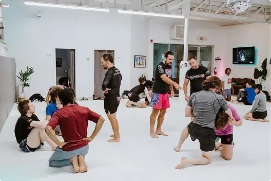 Adults training together in a Brazilian Jiu-Jitsu class during October enrollment season.