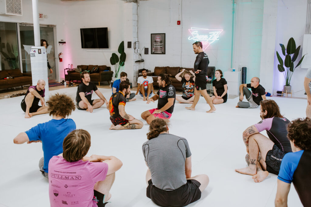 Students listening to the instructor during a beginner Intro to BJJ/101 class at SuperFly BJJ Decatur