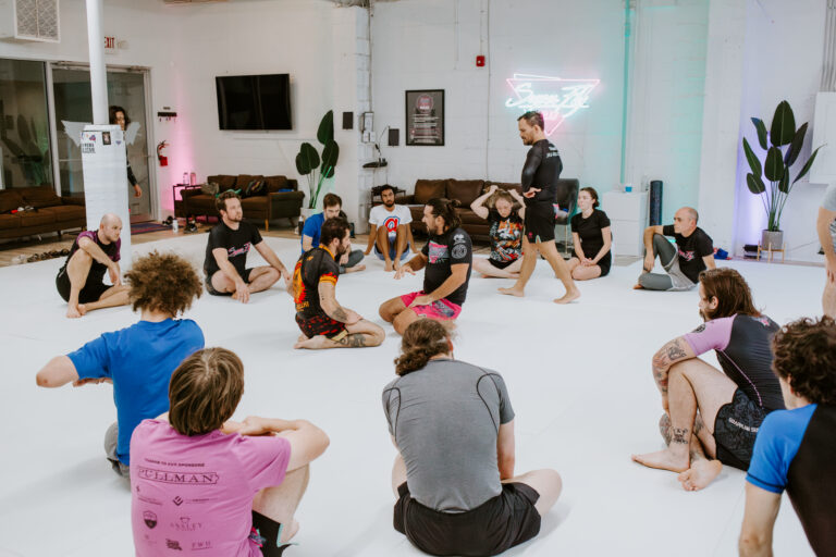 Students listening to the instructor during a beginner Intro to BJJ/101 class at SuperFly BJJ Decatur
