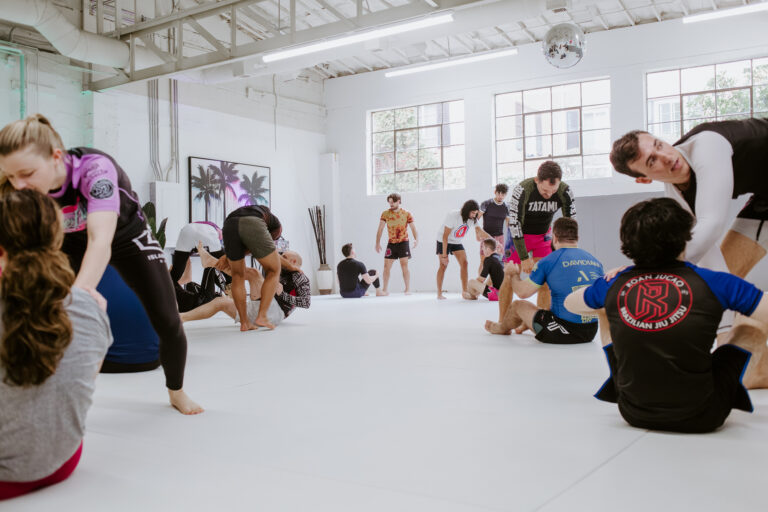 Students practicing no-gi BJJ fundamentals during a partner drilling portion of the Fundamentals class at SuperFly BJJ Decatur.