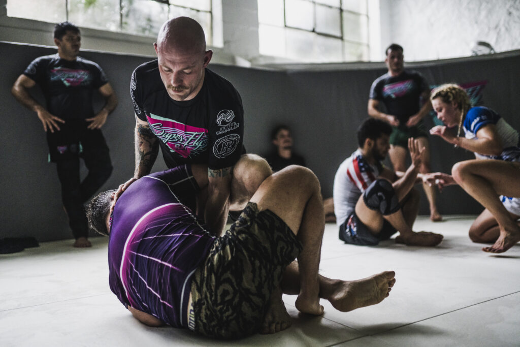 Athletes practicing pressure passing and ground control in the adult intermediate/advanced no-gi bjj class at SuperFly BJJ Decatur
