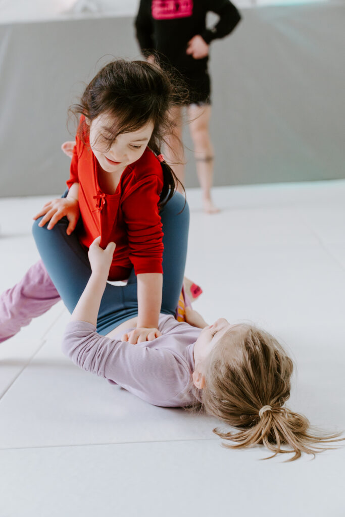 Two children learning how to break the closed guard in BJJ in the Kids 4-6 year old BJJ class at SuperFly BJJ Decatur