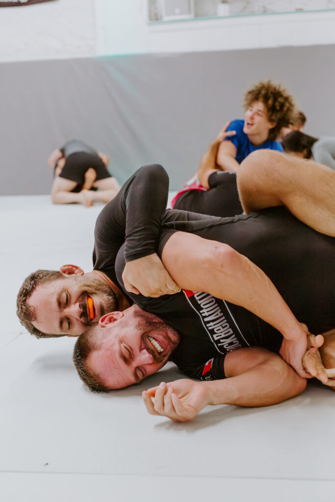 Two students laughing and having fun sparring during an Adult BJJ class at SuperFly BJJ in Decatur.