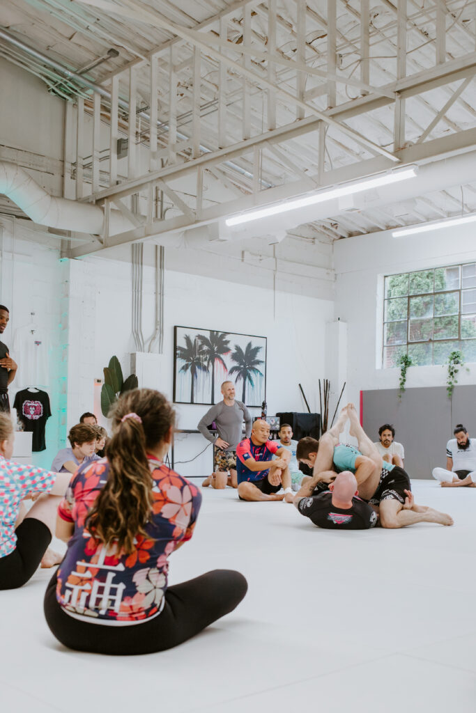 A brazilian jiu jitsu martial arts class learning a technique during an adult beginners class.