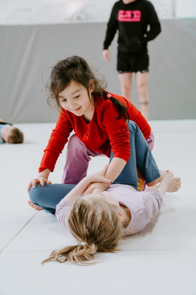 Two kids practicing brazilian jiu jitsu during a kids bjj class at SuperFly BJJ in Decatur.