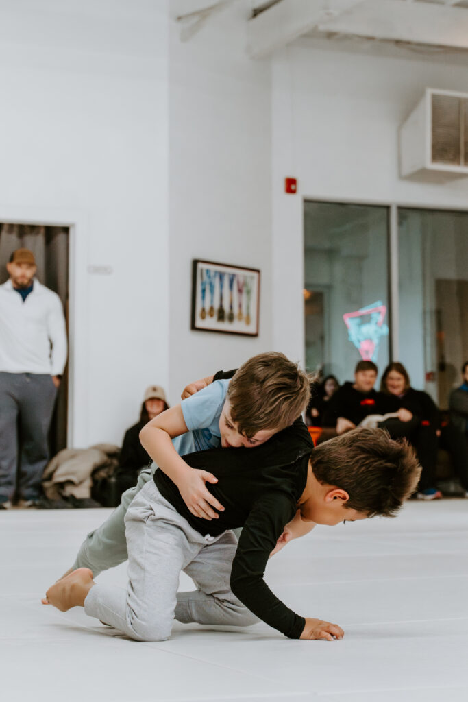 Two kids are sparring during a kids BJJ class at SuperFly BJJ in Decatur, GA.