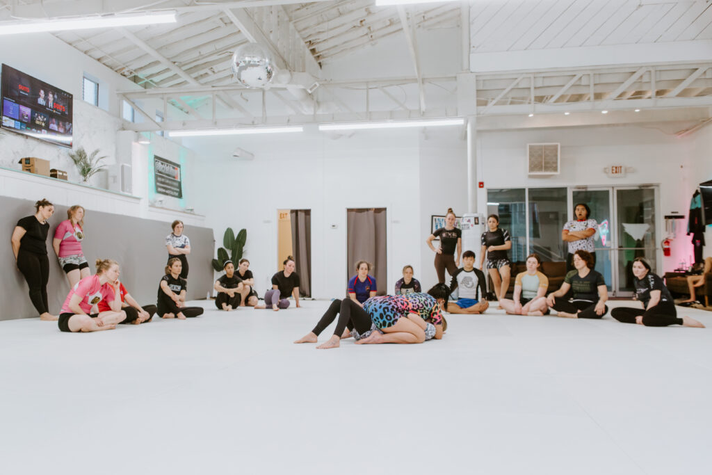 A female instructor demonstrating a technique in a martial arts for women class in Decatur at SuperFly BJJ
